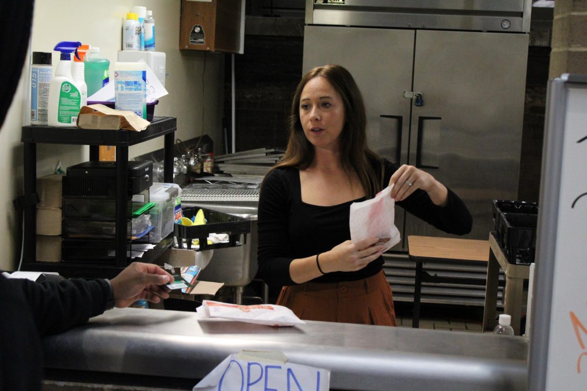 Mrs. Kavanagh handing a customer their cookies at the new corner store. 